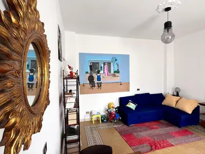 a living room with a blue couch and a mirror at Corso Tugher in Palermo