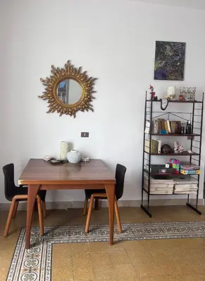 a dining room table with a mirror on the wall at Corso Tugher in Palermo