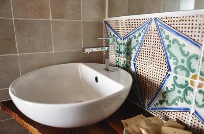a white sink in a bathroom with a tile wall at Santina Suites in Castellammare del Golfo