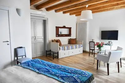 a bedroom with a bed and a couch and a table at Santina Suites in Castellammare del Golfo