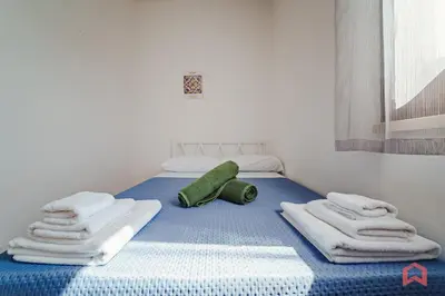 a blue bed in a room with a window at Panoramic Villa with private Pool near Scopello in Scopello