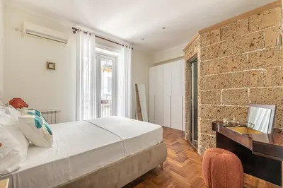 a bedroom with a brick wall and a bed and a desk at Giudici Three Bedrooms Apartment by Wonderful Italy in Palermo