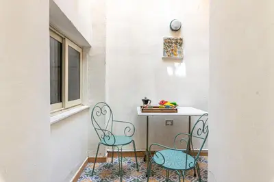 a small table and two chairs on a balcony at Giudici Three Bedrooms Apartment by Wonderful Italy in Palermo