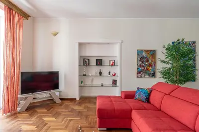 a living room with a red couch and a flat screen tv at Giudici Three Bedrooms Apartment by Wonderful Italy in Palermo