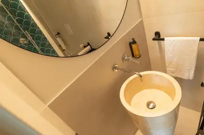 a bathroom with a toilet with a round mirror at Limes in Palermo