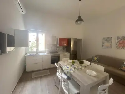 a kitchen and dining room with a table and chairs at Lucrezio Houses in Palermo