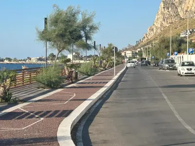 a street with cars parked on the side of the road at Lucrezio Houses in Palermo