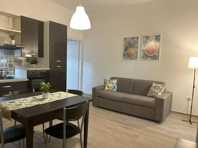 a living room with a table and a couch at Lucrezio Houses in Palermo