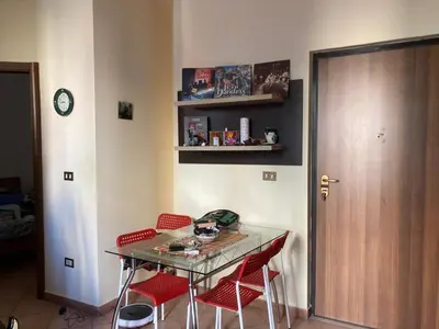 a table with red chairs in a room with a clock at Alessandra guesting house - Palermo in Palermo