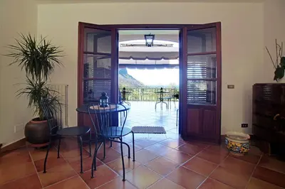 a room with a table and chairs and a door at Poggio di mare in Castelluzzo