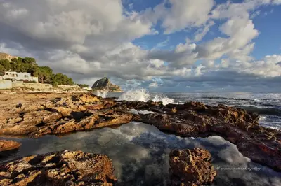 a view of the ocean from a rocky beach at Appartamento La Rosa dei Venti in Porticello
