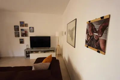 a living room with a couch and a flat screen tv at Appartamento La Rosa dei Venti in Porticello