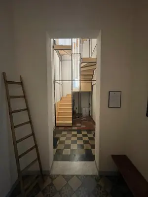 a hallway with a staircase and a checkered floor at Campofranco Studio in Palermo