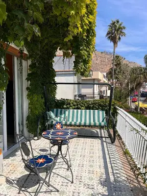 a patio with a table and chairs and a bench at La terrazza sul mare in Palermo