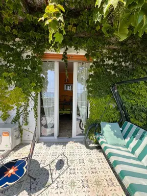 a patio with a bench and a table and a window at La terrazza sul mare in Palermo