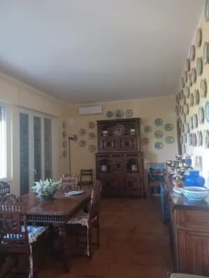 a dining room with a wooden table and chairs at La terrazza sul mare in Palermo
