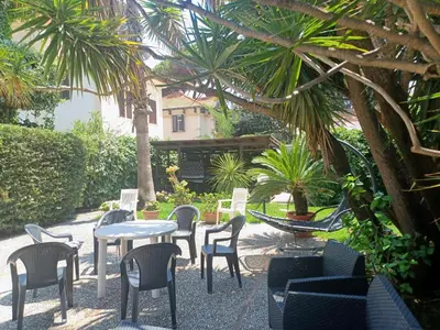 a patio with tables and chairs and palm trees at La terrazza sul mare in Palermo