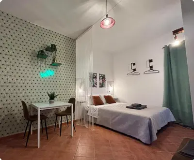 a bedroom with a bed and a table and a desk at Casamori 2- nel cuore di Palermo, mercato Ballarò in Palermo