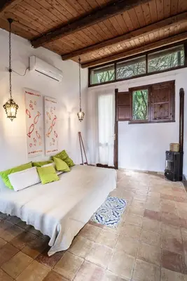 a bedroom with a large white bed with green pillows at Casa Ninfee, immersa nel verde con piscina in comune in Terrasini