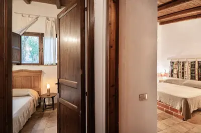 a bedroom with two beds and a door leading into a room at Casa Ninfee, immersa nel verde con piscina in comune in Terrasini