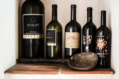 a bunch of wine bottles on a shelf with a spoon at Casa Ninfee, immersa nel verde con piscina in comune in Terrasini