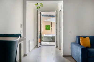 a living room with a blue couch and a tub at Colonna Secret, Private Jacuzzi in Historic Center in Palermo