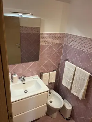 a bathroom with a sink and a toilet and a mirror at Ashur Mondello, sapore di sale in Palermo