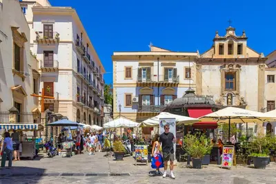 a group of people walking around an outdoor market at La casettina di Dante in Palermo