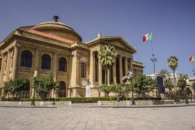 a large building with palm trees in front of it at La casettina di Dante in Palermo
