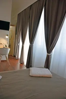 a bedroom with a bed with curtains and a table at Bio Hotel Palermo in Palermo