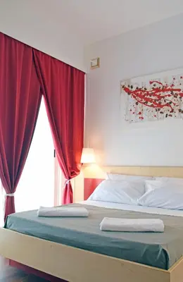 a bedroom with a bed with red curtains at Bio Hotel Palermo in Palermo