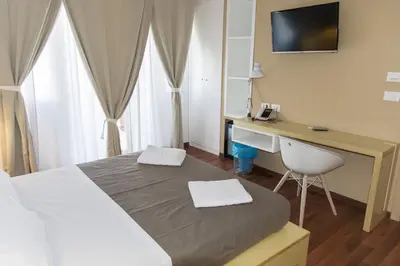 a bedroom with a bed and a desk with a computer at Bio Hotel Palermo in Palermo