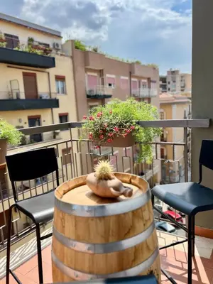 a barrel on a balcony with chairs and plants at Guardian Dream Suite House nel cuore di Palermo in Palermo