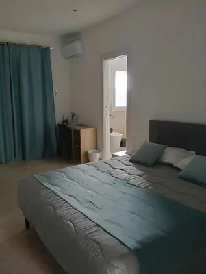 a bedroom with a large bed with blue sheets at Wellness House in Bagheria