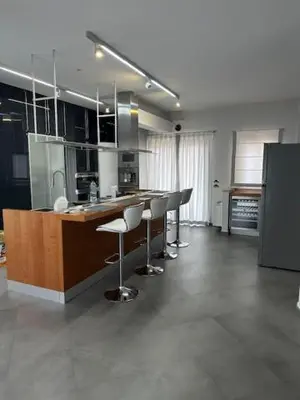 a kitchen with a counter and bar with stools at Villa Oasi Bonita a Mondello in Palermo