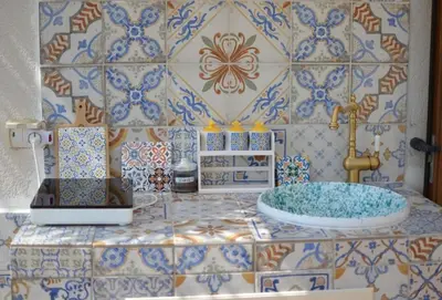 a bathroom with a counter with a sink and tiles at Maioliche Rooms in Campofelice di Roccella