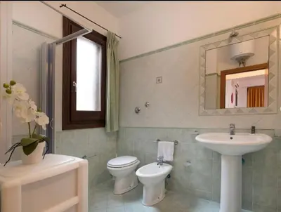 a bathroom with a sink and a toilet and a mirror at Indipendente a S vito lo Capo in San Vito lo Capo