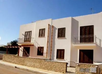 a white building with a fence in front of it at Indipendente a S vito lo Capo in San Vito lo Capo