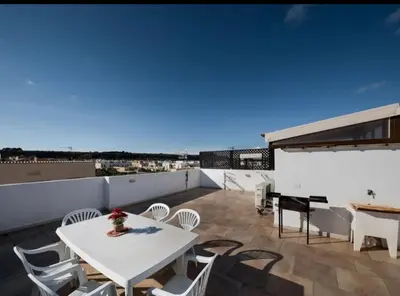 a balcony with a white table and chairs and a piano at Indipendente a S vito lo Capo in San Vito lo Capo