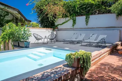 a swimming pool with chairs and a table and a fence at LuminHouse Addaura Pool in Palermo