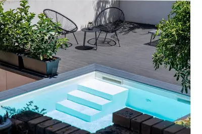 a swimming pool with two chairs and a table at LuminHouse Addaura Pool in Palermo