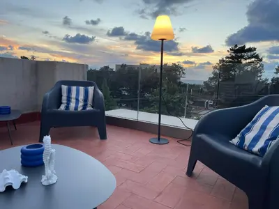 a living room with two chairs and a table and a window at Casetta Ciurì in Terrasini