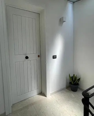 a hallway with a white door and a plant at Casetta Ciurì in Terrasini