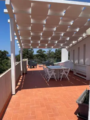 a patio with a table and chairs under awning at Casetta Ciurì in Terrasini