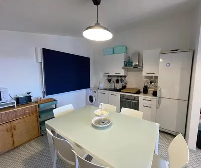 a kitchen with a white table and white chairs at Casetta Ciurì in Terrasini