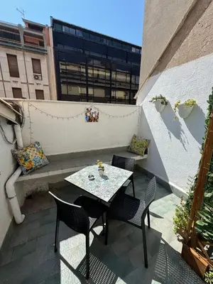 a patio with a table and chairs on a balcony at Petit Charme in Palermo