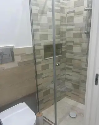 a bathroom with a glass shower with a toilet at Palermo Sunhouse in Palermo