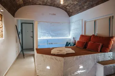 a pair of slippers and towels on a bed at Zahira suite&spa in Palermo