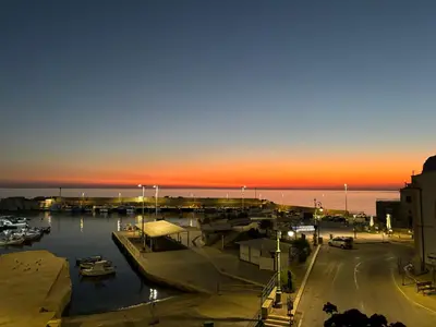 a marina with boats in the water at sunset at Sumarè in Isola delle Femmine