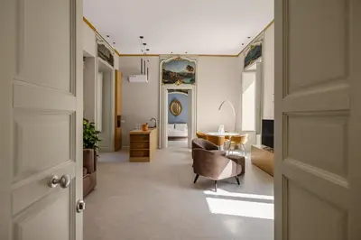 a hallway with a living room with a chair and a table at Palazzo Cavarretta - Le Stanze dei Baroni in Palermo